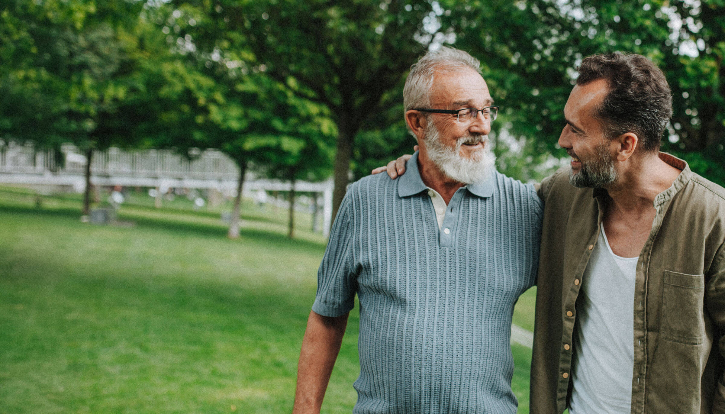 Grandfather smiling and laughing with his grandson outdoors